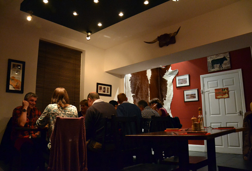 The dining room at La Vaca, with a cowhide on the oxblood wall